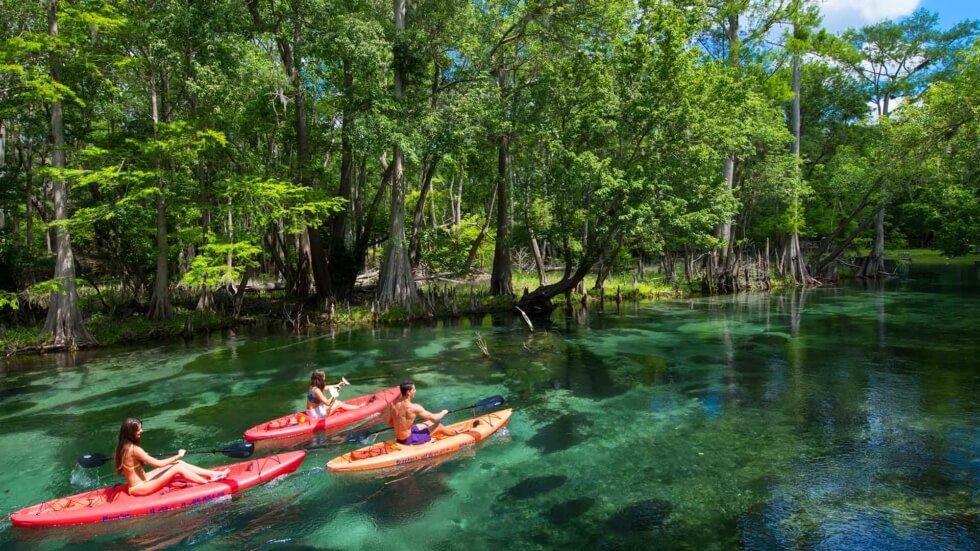 A group of friends kayak down Ichetucknee Springs in Suwannee County, Florida.