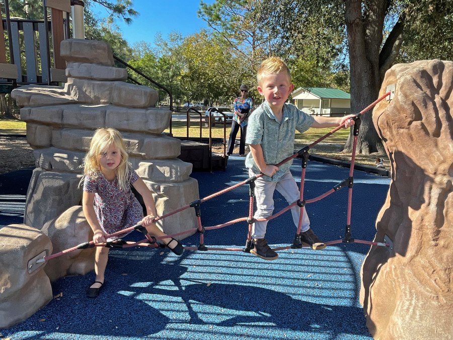 Two children play atop the playground equipment at the Heritage Park in Live Oak, Florida.