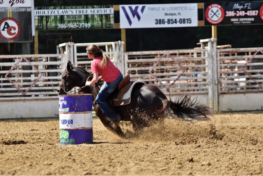 A rider takes a tight turn during a barrel racing event at the Suwannee River Riding Club Rodeo in Branford, Florida. 