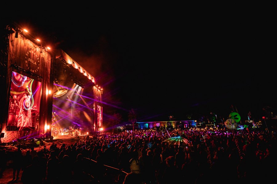 Festival-goers stand before a stage displaying a laser light show during Suwannee Hulaween festival held at Spirit of Suwannee Music Park.