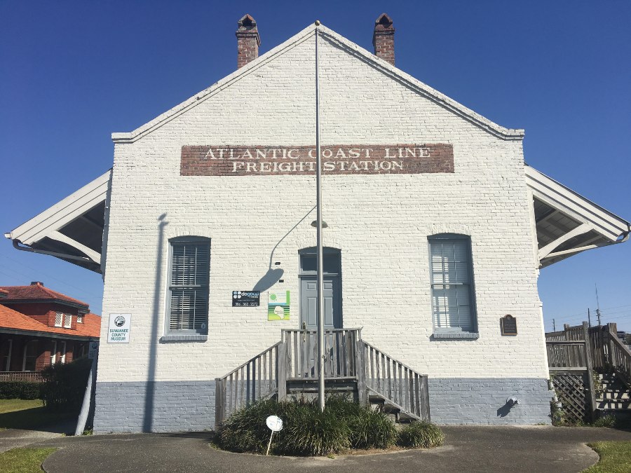 The white brick facade of the Suwannee County Museum, a popular historical attraction in Live Oak, FL.