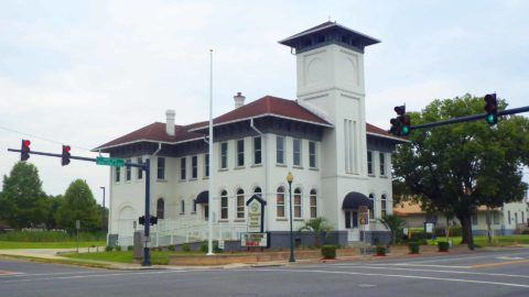 The historic Old Live Oak City Hall stands on the corner of a main street intersection in Live Oak, FL.