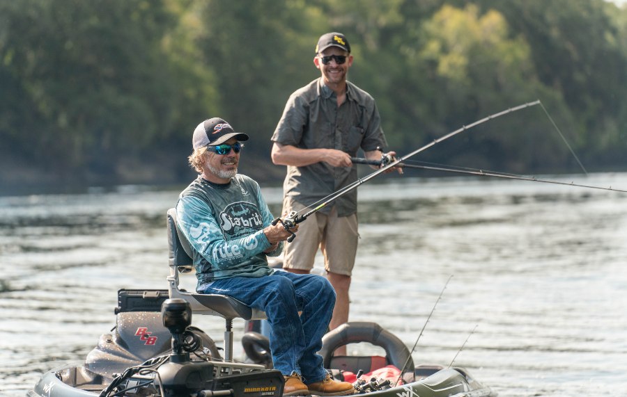 Two men bass fishing on a river in Suwannee County, Florida, enjoying a relaxing day on the water.