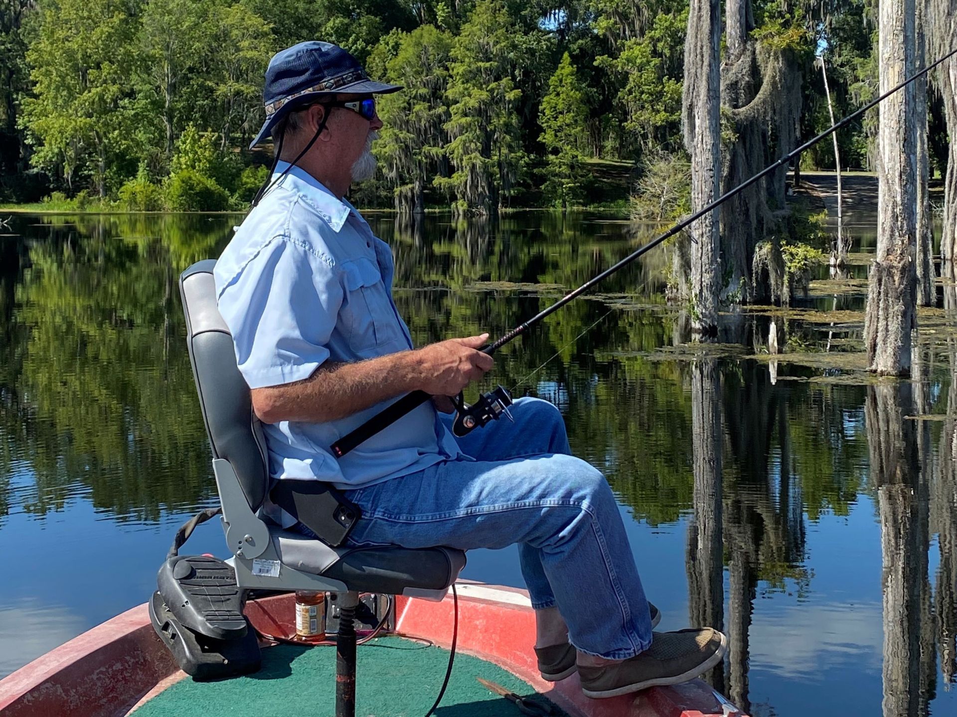 An angler holds a fishing rod as he sits in a chair onboard a small fishing boat in Suwannee County, Florida. 