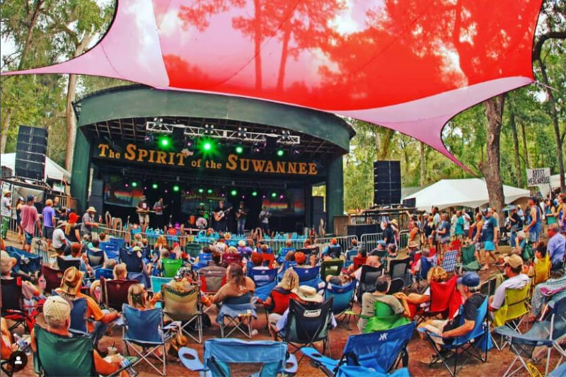 A sea of concert-goers sit in lawn chairs watching a band play at the Suwannee Roots Revival event in Suwannee County, Florida.