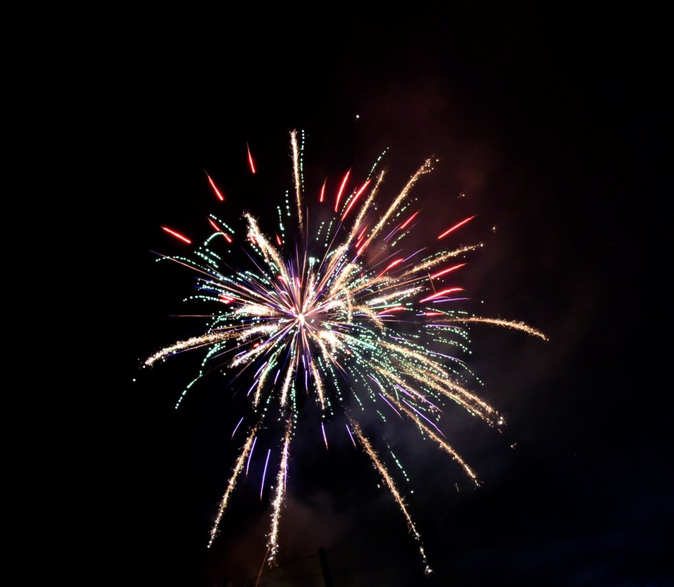 A vibrant fireworks display illuminates the night sky with a burst of multicolored sparks in Suwannee County, Florida.